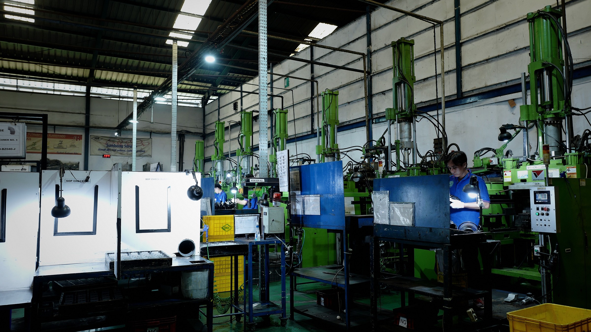 Row of green cold runner injection presses on the Cikupa factory floor